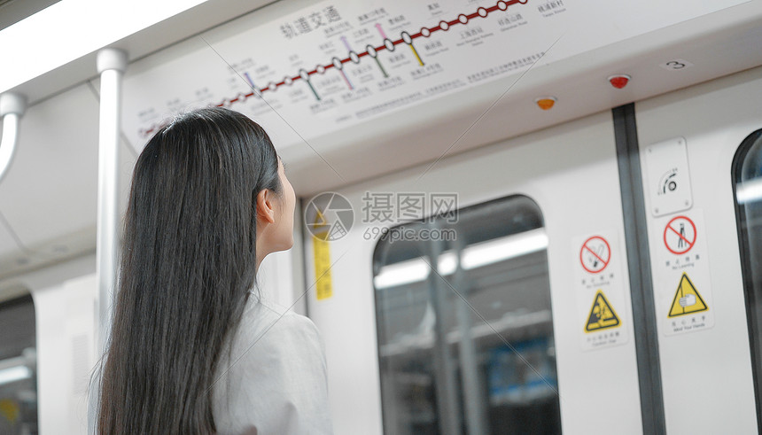 地铁里通勤上班族女生正在看地图图片