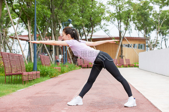 运动美女在户外做手臂拉伸图片