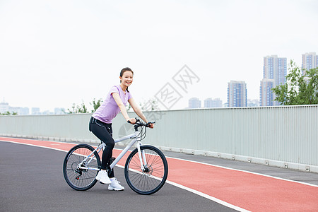 户外健身美女青年女性户外公园里骑行背景