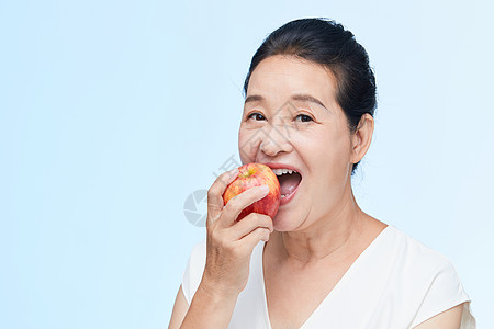 吃苹果女人老年女性吃苹果背景