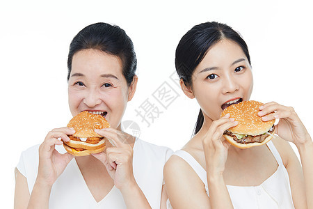 年轻美女和老年女性一起吃汉堡图片