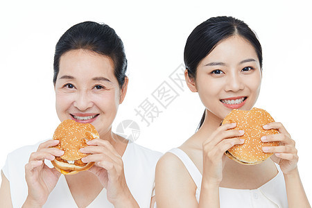 年轻美女和老年女性一起吃汉堡图片