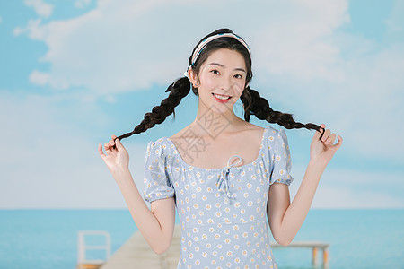 穿着蓝色碎花裙的海边夏日少女图片