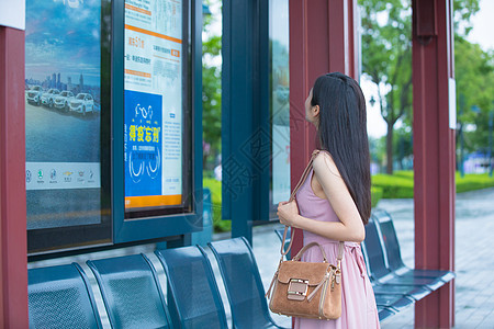 看公交站台指示牌的女性高清图片