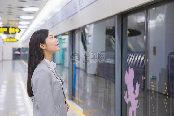 看地铁指示牌的商务女性图片