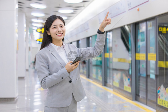 看地铁指示牌的商务女性图片