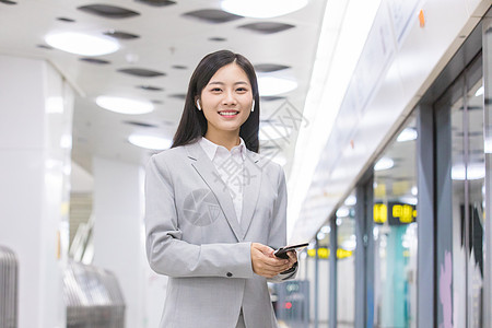 商务女性在地铁站玩手机高清图片