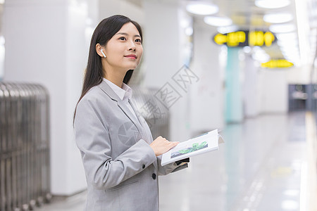 商务女性在地铁站内看书等待图片