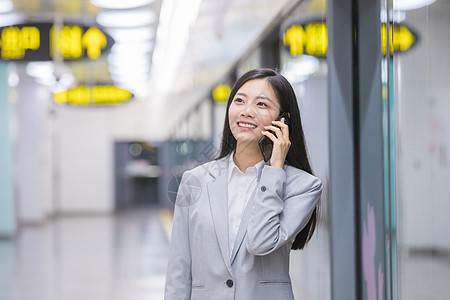 商务电话地铁站内打电话的商务女性背景