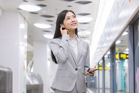 地铁站内打电话的商务女性背景图片