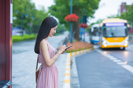 公交车站台等待公交的女性背景图片