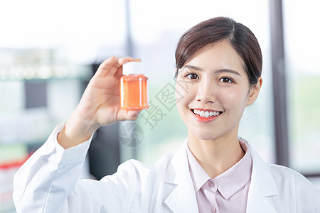 年轻女医生手拿药瓶展示高清图片