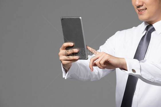 商务男性拿平板电脑特写图片