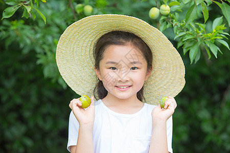 戴帽子小女孩手拿李子图片