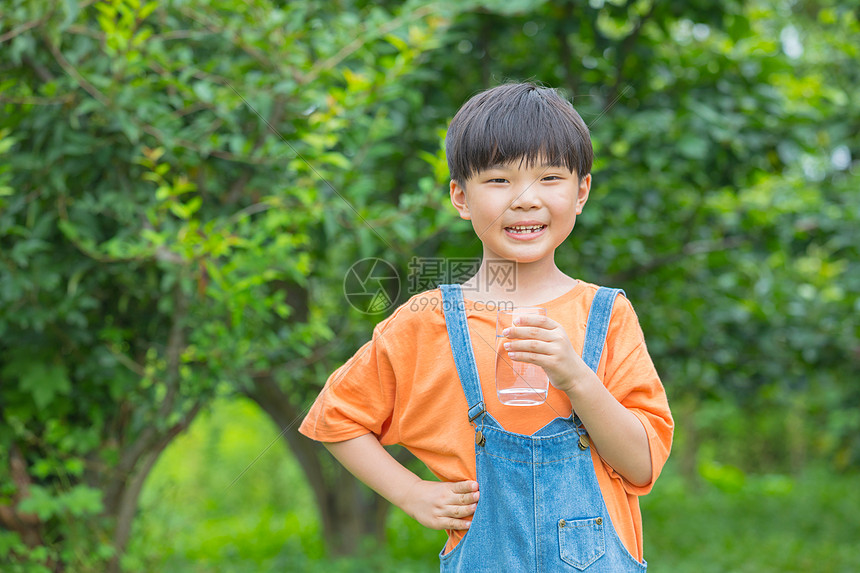 小男孩在户外喝水图片