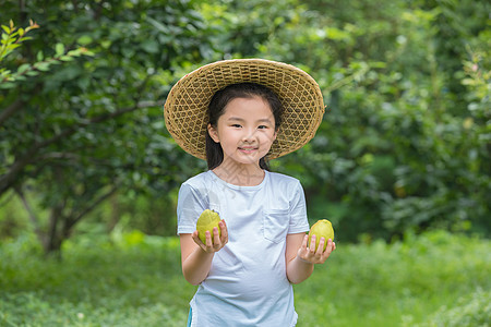 小女孩在户外手拿二只梨图片