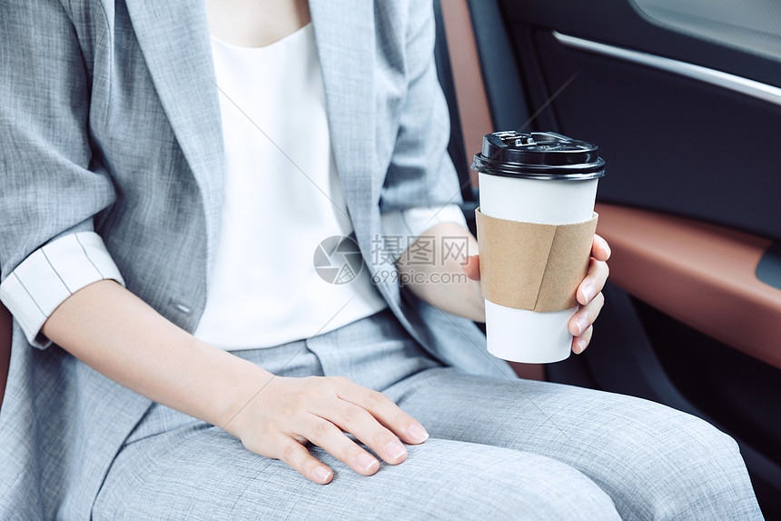 商务女性在汽车上喝咖啡图片