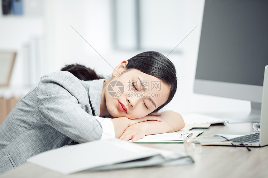 商务女性加班劳累趴桌子睡觉图片