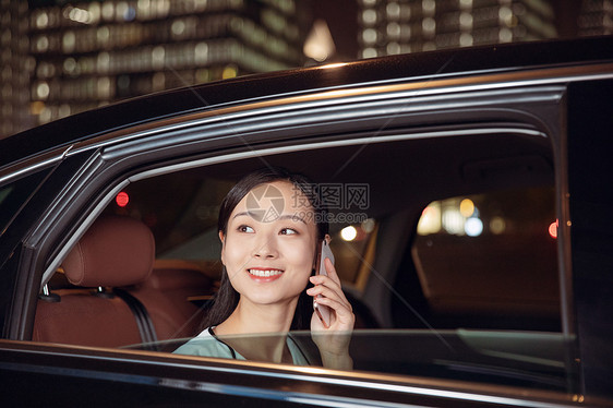 夜晚白领女性乘坐专车打电话图片