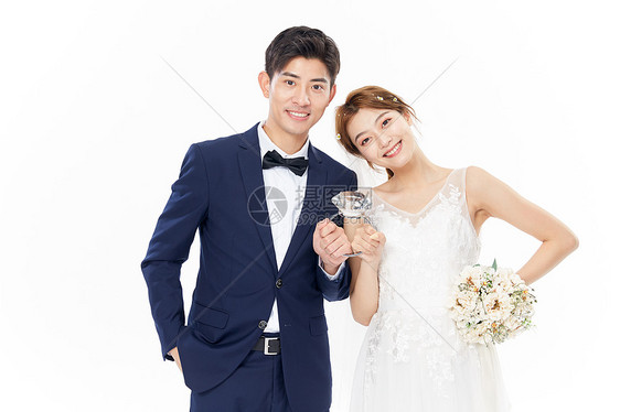 年轻夫妻一起拿大戒指拍婚纱照图片