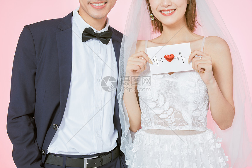 新婚夫妻一起拿着结婚请柬图片