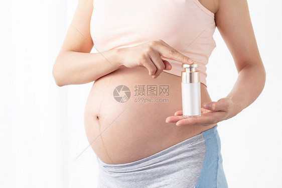 孕妇手拿润肤乳图片