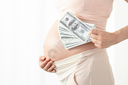 孕妇手拿美钞背景图片