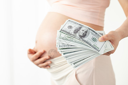 孕妇手拿美钞背景图片