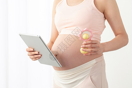 孕妇拿着平板电脑和玩具图片