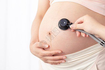 孕妇拿听诊器听肚子的胎动图片