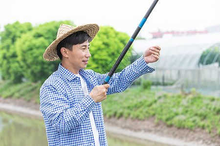 农夫乡间河岸钓鱼拿鱼钩图片