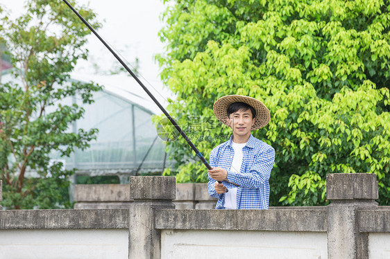 农夫乡间河岸钓鱼图片