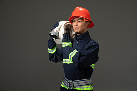 扛消防水袋的消防员形象图片