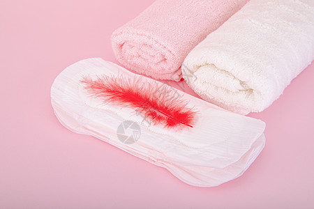 粉色羽毛粉色背景上的卫生巾背景