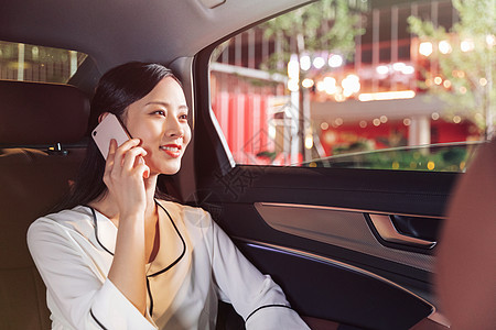 白领商务女性乘坐专车打电话图片