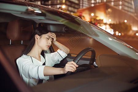 女性夜晚开车疲劳驾驶背景图片