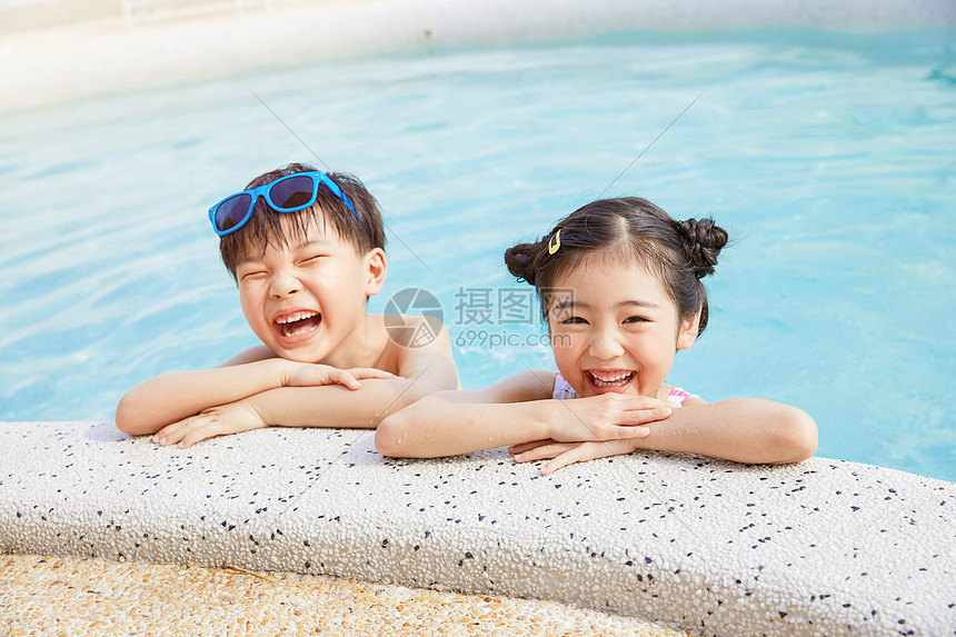 小男孩和小女孩开心趴在泳池边图片