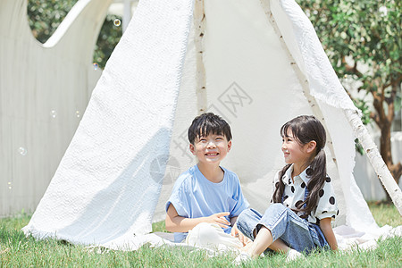 小男孩和小女孩在帐篷里吹泡泡图片