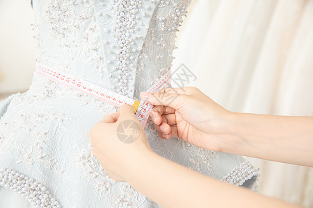 婚纱模特使用皮尺测量婚纱尺寸的设计师背景