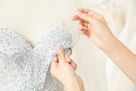 服装设计师缝制婚纱特写图片