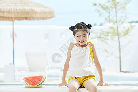 小女孩坐在西瓜旁图片
