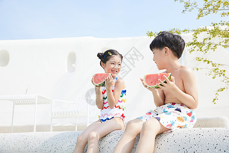 小男孩和小女孩坐在泳池边开心吃西瓜高清图片