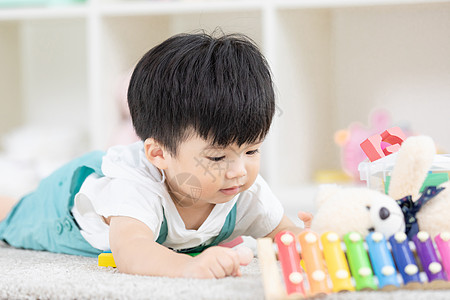 小孩子做作业可爱幼儿宝宝坐地毯上玩玩具背景