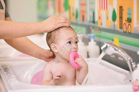 阿姨给婴幼儿洗澡特写图片