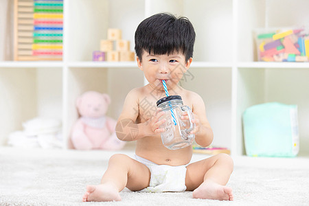 小孩子喝水可爱宝宝居家地毯上嬉戏背景