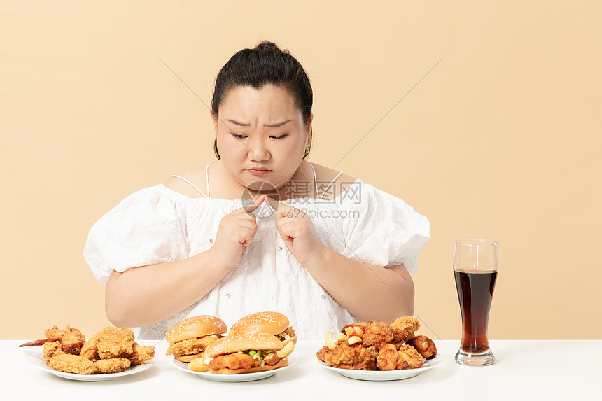 肥胖女生纠结吃垃圾油炸食品