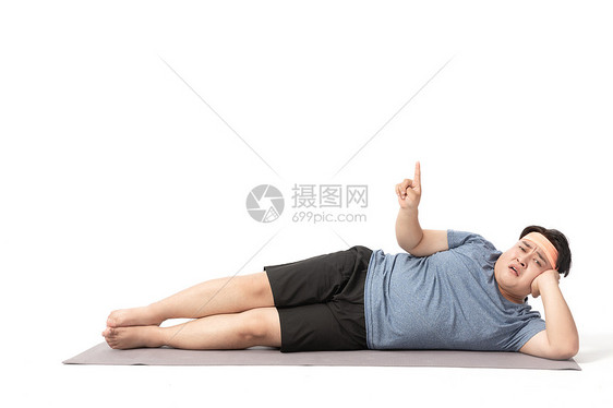 肥胖男士躺在瑜伽垫手指上面图片