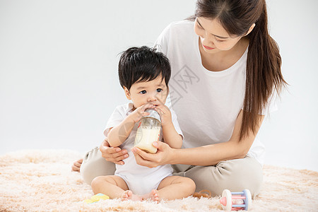 年轻妈妈用奶瓶辅助宝宝喝奶背景图片