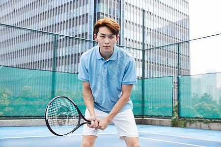 在网球场打网球的青年男性高清图片
