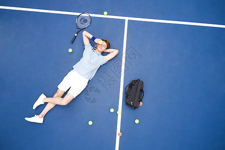 躺在网球场地上休息的青年男性图片